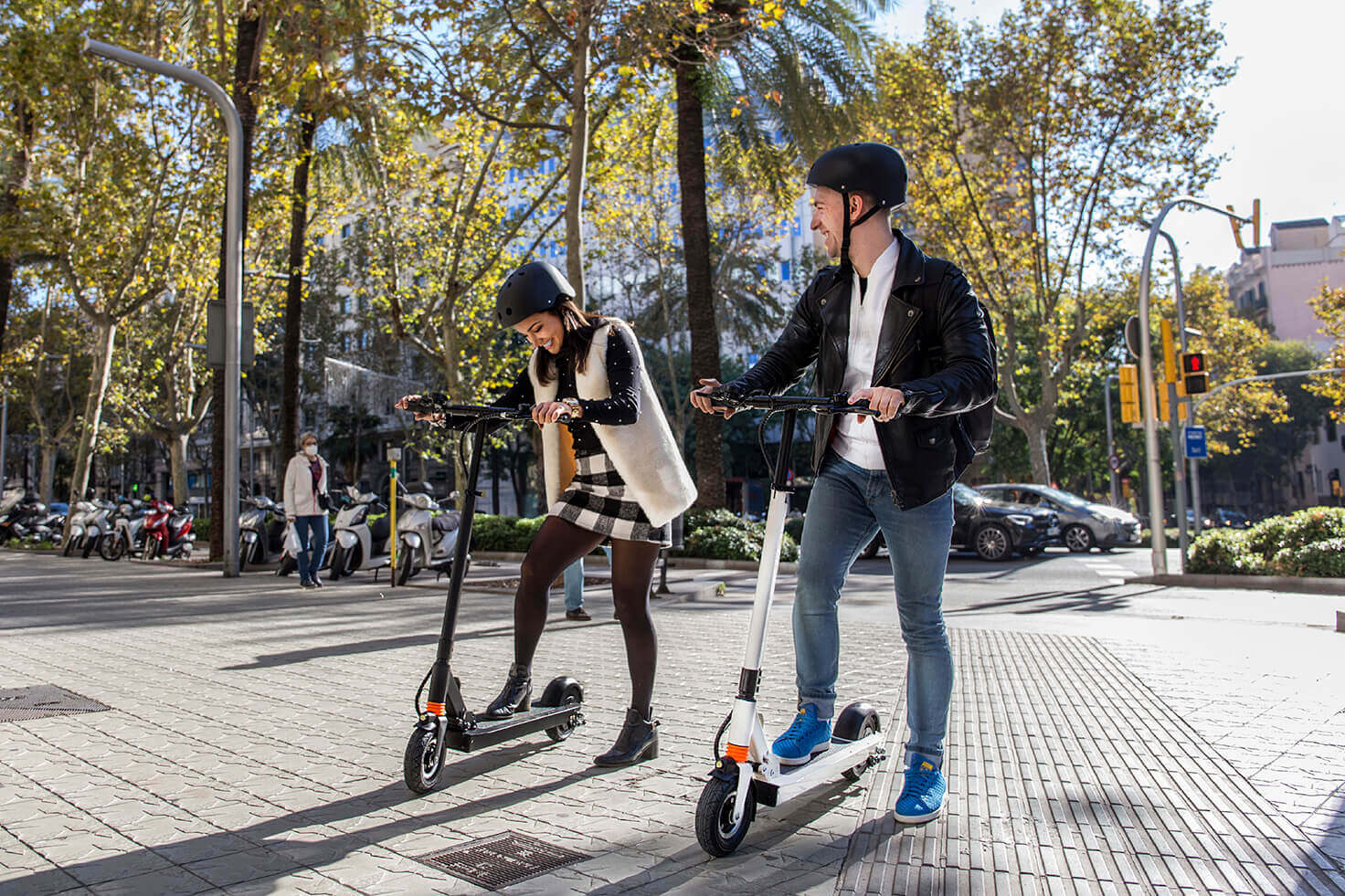 Dos personas circulando en patinetes eléctricos por Barcelona